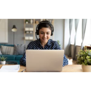 Femme portant un casque audio micro se tenant devant un ordinateur.