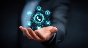 Main tenant une icône lumineuse représentant un téléphone numérique, entourée d'autres symboles de communication, représentant une technologie de communication intégrée.